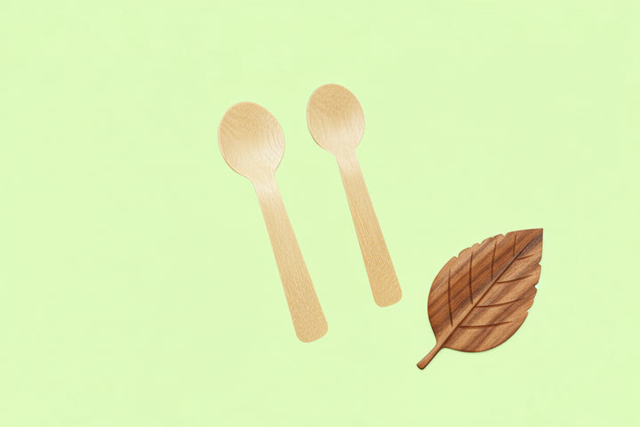Two wooden spoons on a light green background